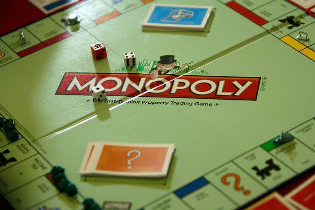 <p>Alex Wong/Getty Images</p> <em>Monopoly</em> game board, cards, dice and playing pieces