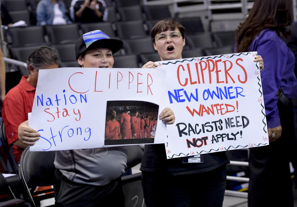 Fans hold up signs in support of the Los Angeles Clippers before Game 5 of an opening-round NBA basketball playoff series between the Clippers and the Golden State Warriors on Tuesday, April 29, 2014, in Los Angeles. NBA Commissioner Adam Silver announced Tuesday that Clippers owner Donald Sterling has been banned for life by the league. (AP Photo)