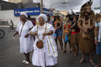 Miembros de la comunidad indígena se suman a seguidores de religiones afrobrasileñas en Salvador, Brasil, en una protesta el domingo 18 de septiembre de 2022. Los asistentes pedían medidas contra proyectos que puedan causar daños medioambientales en un gran sistema de deudas. (AP Foto/Rodrigo Abd)