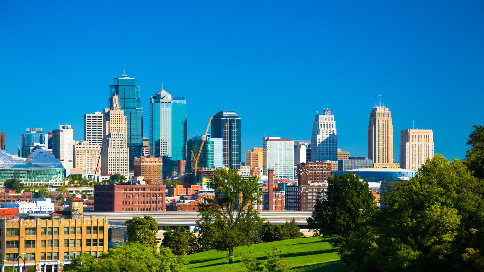 Downtown Kansas City skyline with Penn Valley Park in the foreground and a vivid blue sky in the background.