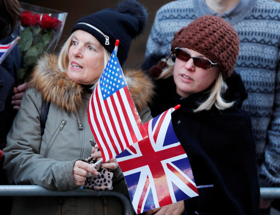 People hold U.S. and British flags as they wait for Britain's Prince Harry and his fiancee Meghan Markle to attend an event in the U.K. on December 1, 2017. REUTERS/Eddie Keogh