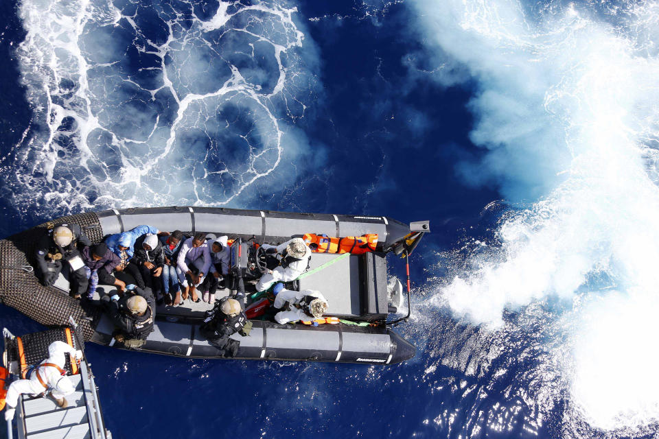 FILE - Rescued migrants sit in a German Navy boat besides Finish Special Forces prior to board the German combat supply ship "Frankfurt am Main" during EUNAVFOR MED Operation Sophia in the Mediterranean Sea off the coast of Libya on March 29, 2016. A confidential European Union military report calls for the continued support and training of Libya’s coastguard and navy despite concerns about their treatment of migrants, a mounting death toll at sea, and the continued lack of any central authority in the North African nation. The report circulated to EU officials on Jan. 4 and obtained by The Associated Press offers a rare insight into Europe’s determination to cooperate with Libya and its role in the interception and return of thousands of men, women and children to a country where they face insufferable abuse. (AP Photo/Matthias Schrader, File)