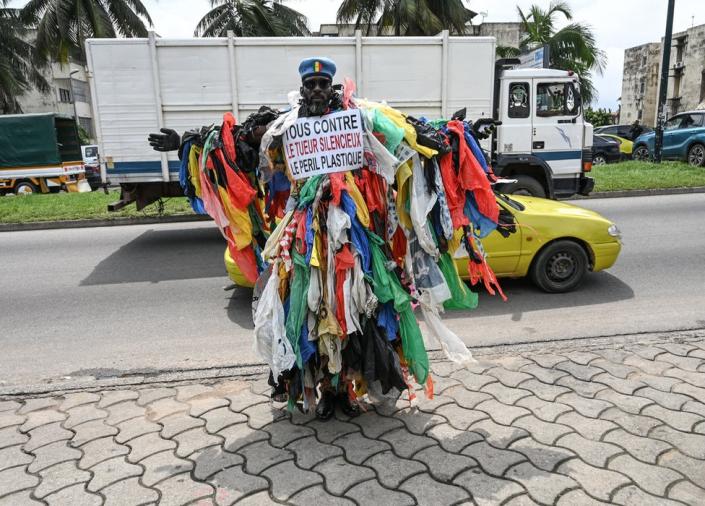 A man posing in the street dressed in plastic waste - June 5.