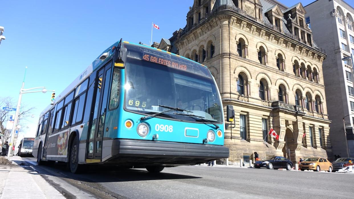 An STO bus is seen in downtown Ottawa. The board of directors for the Gatineau, Que., transit authority has put forward a resolution calling for a crackdown on Quebecers who keep their Ontario licence plates rather than paying renewal fees that could go toward supporting transit. (Philippe Turgeon/CBC - image credit)