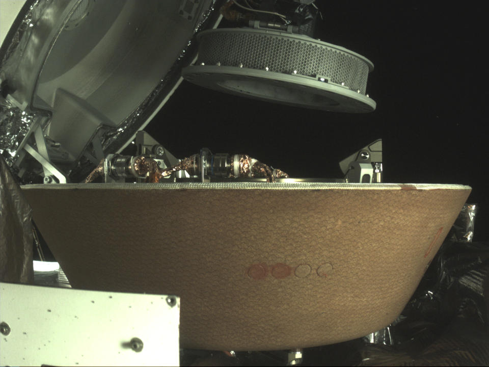 FILE - In this undated image provided by NASA, a sample container hovers over a capsule on the OSIRIS-REx spacecraft near the asteroid Bennu. On Sunday, Sept. 24, 2023, the OSIRIS-REx spacecraft will fly by Earth and drop off what is expected to be at least a cupful of rubble it grabbed from the asteroid Bennu, closing out a seven-year quest. (NASA via AP, File)