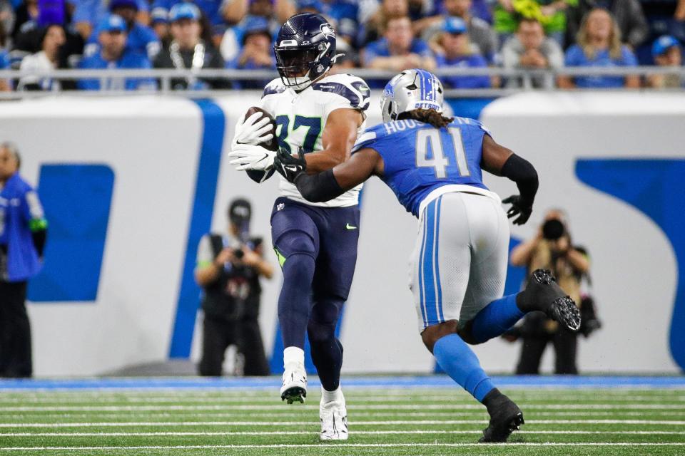 Detroit Lions linebacker James Houston tackles Seattle Seahawks tight end Noah Fant after a catch during the first half at Ford Field in Detroit on Sunday, Sept. 17, 2023.