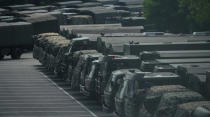 In this image made from video, armed police vehicles are parked outside Shenzhen Bay Stadium in Shenzhen, near Hong Kong, Friday, Aug. 16, 2019. Satellite photos show what appear to be armored personnel carriers and other vehicles belonging to the China's paramilitary People's Armed Police parked in a sports complex in the city of Shenzhen, in what some have interpreted as a threat from Beijing to use increased force against pro-democracy protesters across the border in Hong Kong.(AP Photo/Dake Kang)