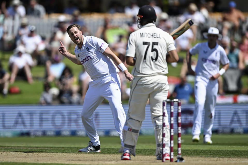 England's Ollie Robinson, left, celebrates taking the wicket of New Zealand's Daryl Mitchell on the second day of their cricket test match in Tauranga, New Zealand, Friday, Feb. 17, 2023. (Andrew Cornaga/Photosport via AP)