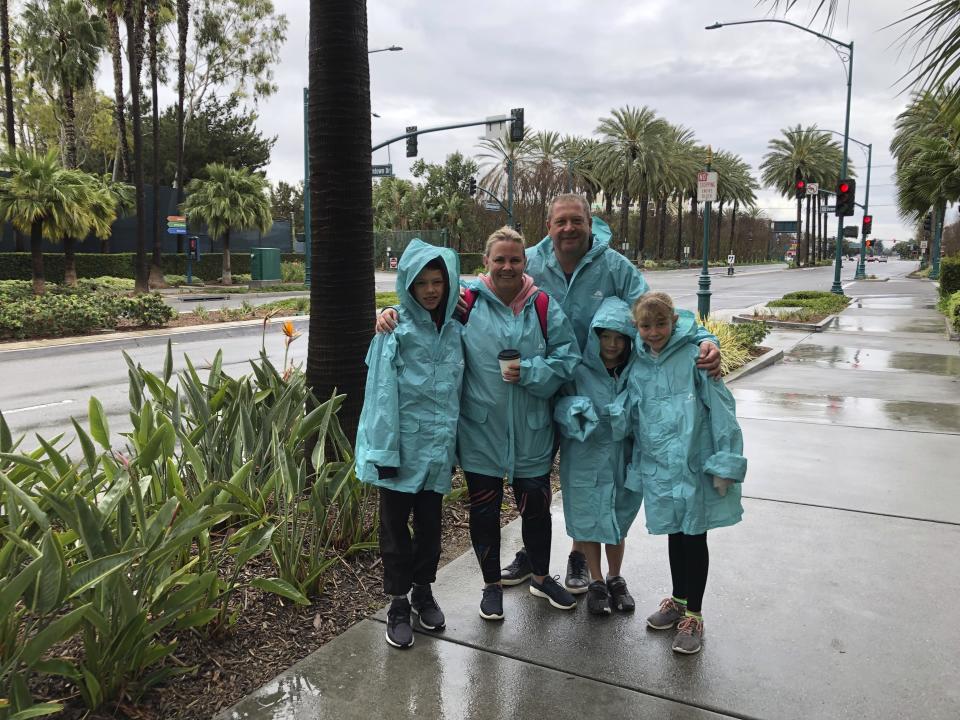 Rochelle Van Eysden, 46, and Jeremy Grice, 45, with children Max, 11; Ava, 9; and Leo, 6 stand outside Disneyland in Anaheim, Calif. on Friday, March 13, 2020. They traveled from New Zealand to Disneyland and planned to stay three days but their trip to the resort was cut short to two by the closure. They're supposed to head on a seven-day cruise this weekend down to Mexico and that trip is also on shaky footing, she said. Disneyland is closing its doors for the rest of the month, shuttering one of California's best-known attractions as the state hurries to stop the spread of the coronavirus. (AP Photo/Amy Taxin)