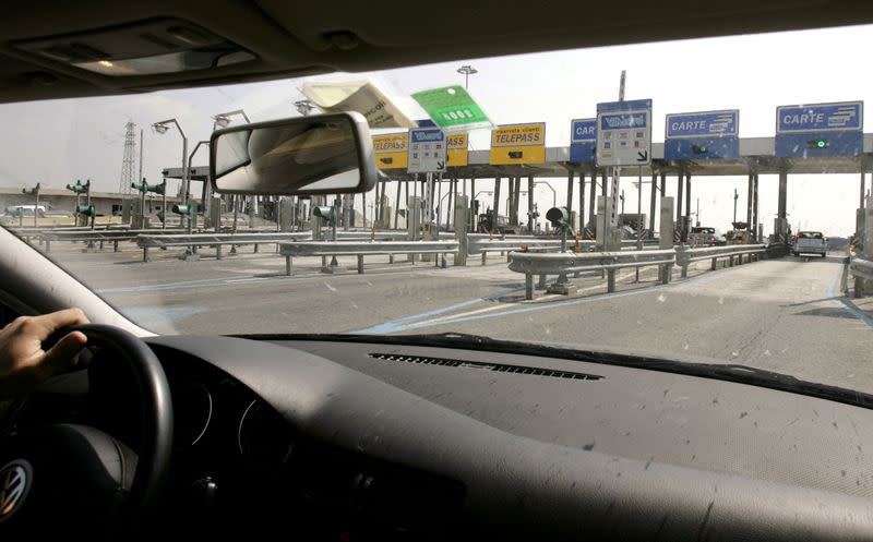 FILE PHOTO: A driver approaches an Autostrade motorway toll along a highway on the outskirts of Rome April 24, 2..