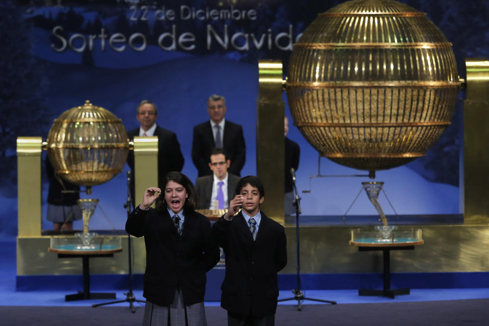 School children sing out the numbers for the top prize of Spain's Christmas lottery known as 'El Gordo' or 'The Fat One', as they hold lottery balls, in Madrid, Sunday, Dec. 22, 2013. Millions of Spaniards are glued to television as the country's cherished Christmas lottery, the world's richest, distributes a bounty of 2.5 billion euros ($3.4 billion) in prize money to winning ticket owners. The draw is so popular that most of Spain's 46 million inhabitants traditionally watch some part of it live in the hope that the school children singing out winning numbers will call out their ticket. The top prize, known as "El Gordo" (The Fat One), gives lucky winners 400,000 euros per ticket, while the second-best number nets 125,000 euros. Unlike lotteries that offer one large jackpot, Spain's yuletide draw sprinkles winnings of values lower than El Gordo on thousands of ticket holders. (AP Photo/Andres Kudacki)