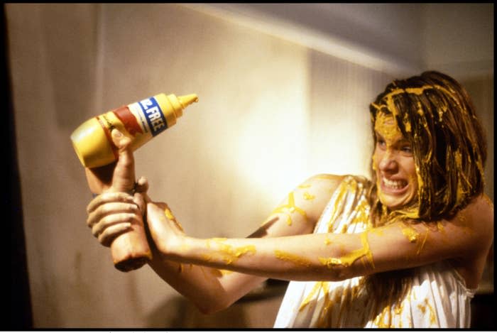 A woman covered in mustard battles a disembodied hand in the opening scene of "Waxwork II: Lost in Time"