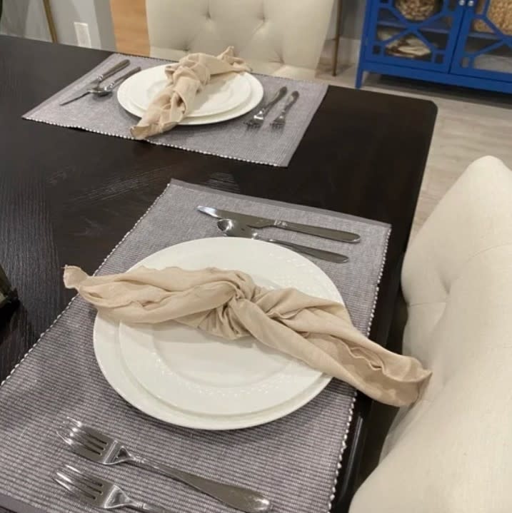 Reviewer's photo of two table settings with the placemats, plus plates, napkins, and cutlery