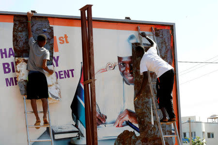 People tear a poster of former Gambian president Yaya Jammeh in Broussbi, Gambia, December 4, 2016. REUTERS/Thierry Gouegnon