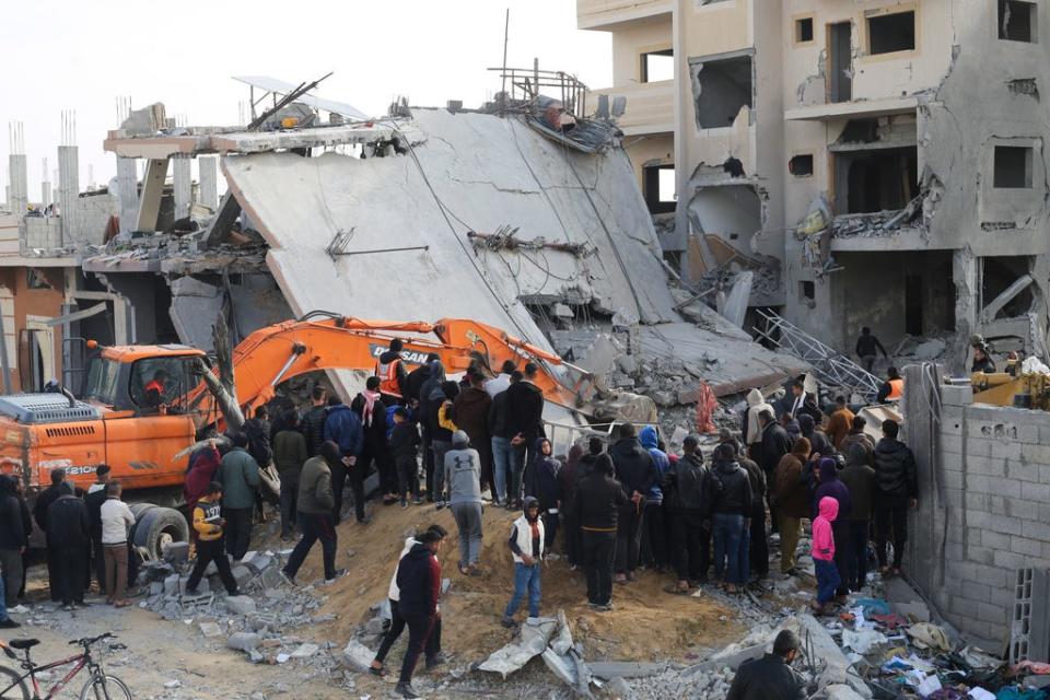 Palestinians look at the destruction after an Israeli strike on a residential building in Rafah, Gaza Strip, Friday, Feb. 16, 2024.