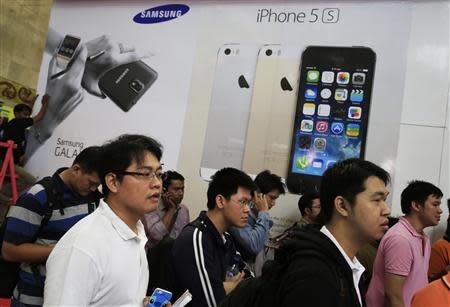 People queue to buy mobile phones during the Digital Imaging Expo in Jakarta March 5, 2014. REUTERS/Beawiharta