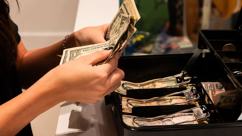 Brook Anderson counts cash from the cash box on Black Friday at Thread at City Creek Center in Salt Lake City on Friday, Nov. 24, 2023. Consumer debt could be on the rise and hidden behind problematic reporting requirements.