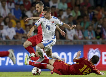 Slovakia's Robert Mak (C) fights for the ball with Macedonia's Muarem Muarem (L) and Arijan Ademi during their Euro 2016 qualifying soccer match in Zilina, Slovakia, June 14, 2015. REUTERS/David W Cerny