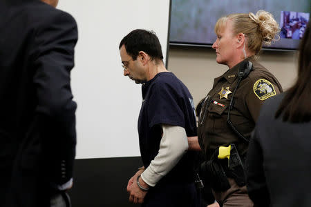 Larry Nassar, a former team USA Gymnastics doctor, who pleaded guilty in November 2017 to sexual assault charges, is escorted into the courtroom during his sentencing hearing in Lansing, Michigan, U.S., January 22, 2018. REUTERS/Brendan McDermid. REUTERS/Brendan McDermid