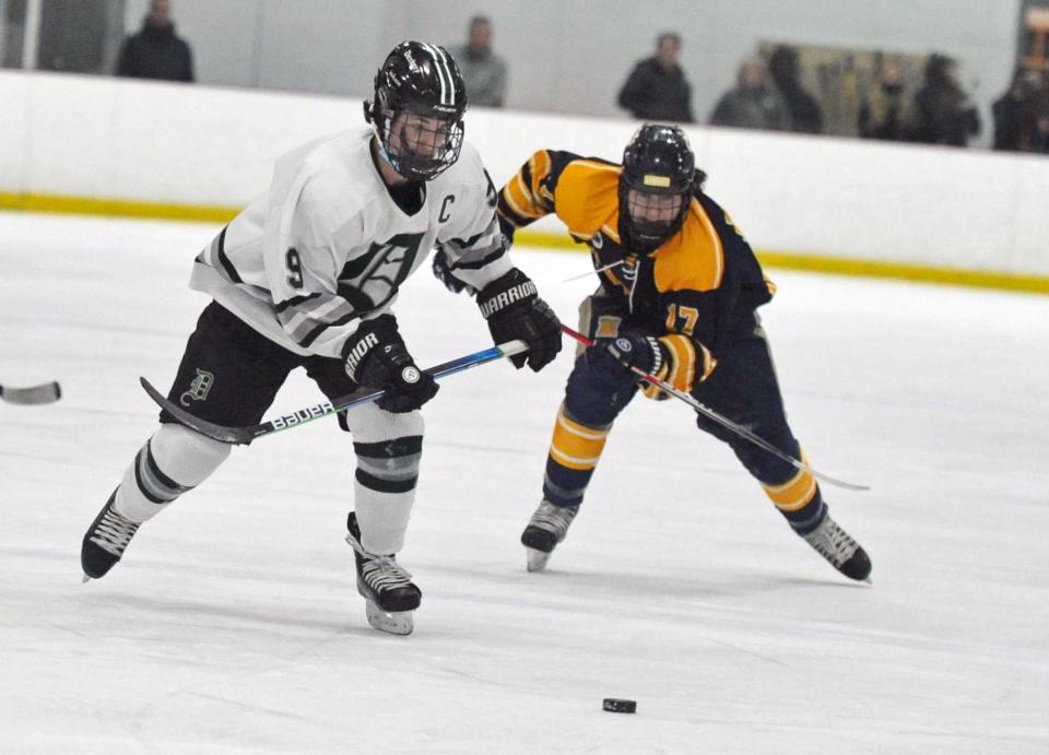 Duxbury's Brendan Bonner, left, and Hanover's Liam Joy race for a loose puck during boys hockey at The Bog in Kingston, on Monday, Jan. 31, 2022.