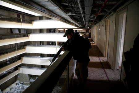 An Iraqi soldier holds his weapon while looking over a balcony between the damaged floors in the five-star Ninewah Oberoi Hotel in Mosul city, Mosul, Iraq January 30, 2017. Picture taken January 30, 2017. REUTERS/Ahmed Jadallah