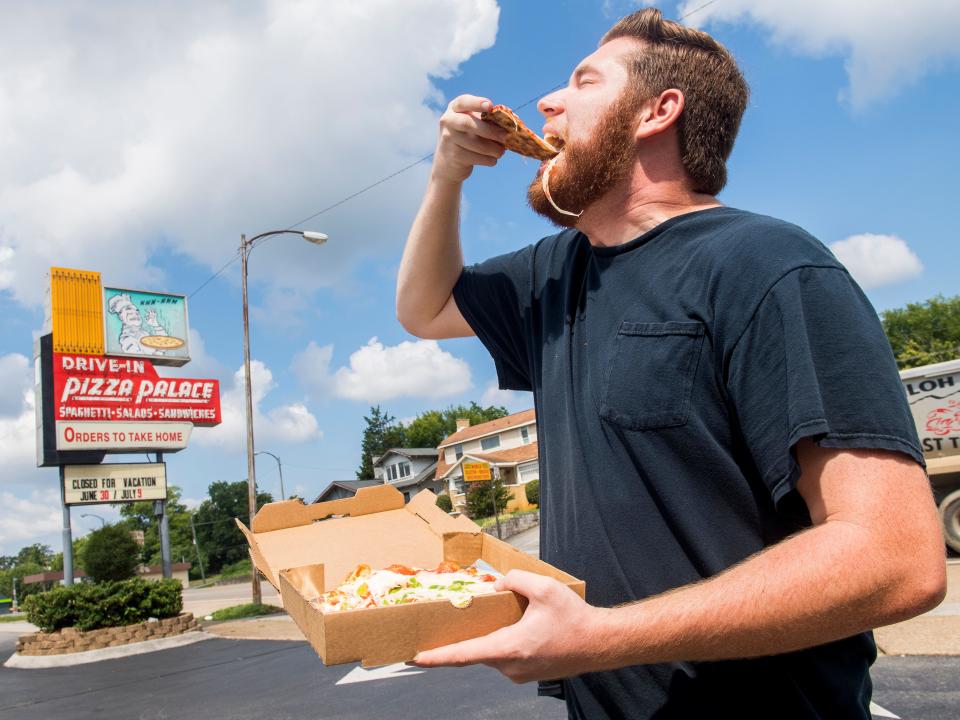 Ryan Wilusz, now downtown growth and development reporter for Knox News, enjoys a slice at Pizza Palace in 2018 while trying to complete his Knoxville bucket list in one day.