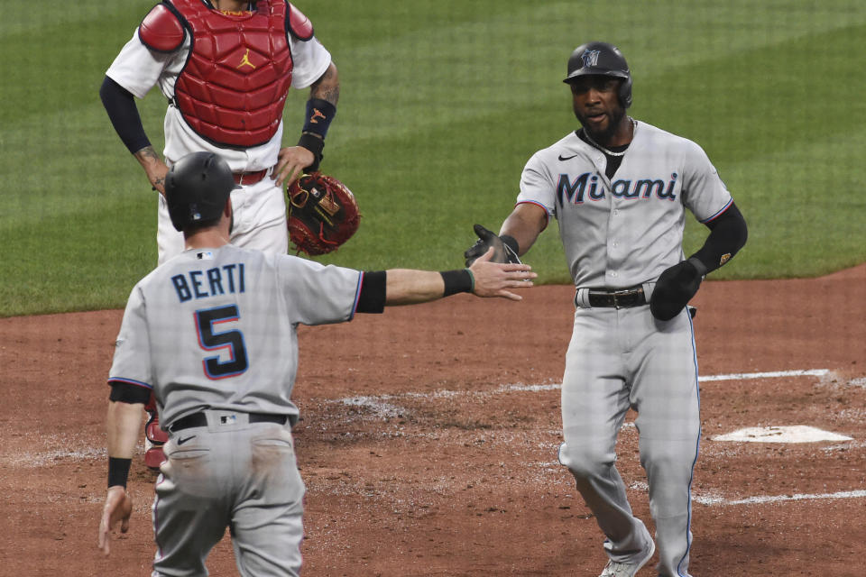 Miami Marlins center fielder Starling Marte, right, and teammate Miami Marlins' Jon Berti react after scoring two runs against the St. Louis Cardinals during the third inning of a baseball game Monday, June 14, 2021, in St. Louis. (AP Photo/Joe Puetz)