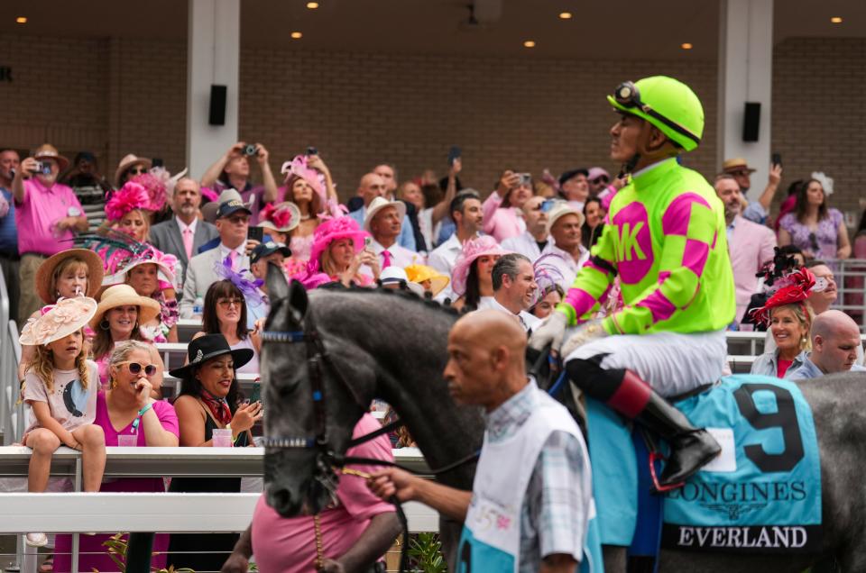 A young girl sits on the railing as she watches Oaks contender Overland walk around the Paddock before the 2024 Kentucky Oaks race Friday, May 3, 2024 in Louisville, Kentucky.