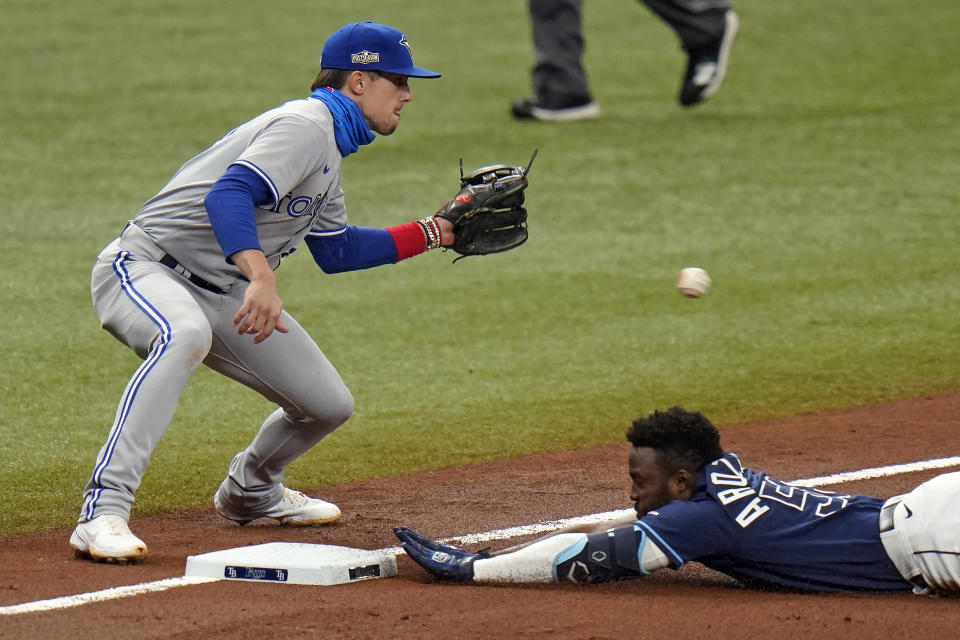 Tampa Bay Rays' Randy Arozarena slides into third base with a triple as Toronto Blue Jays' Cavan Biggio, left, waits for the throw during the fourth inning of Game 1 of a wild card series playoff baseball game Tuesday, Sept. 29, 2020, in St. Petersburg, Fla. (AP Photo/Chris O'Meara)