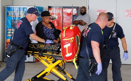 A passenger is transported by emergency workers after disembarking the Bahamas Paradise Cruise Line ship, Grand Celebration, in Riviera Beach