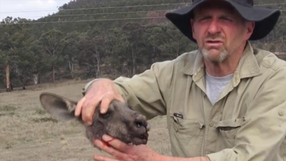 The Kangaroos Alive member is seen holding one of the decapitated heads. Source: Kangaroos Alive