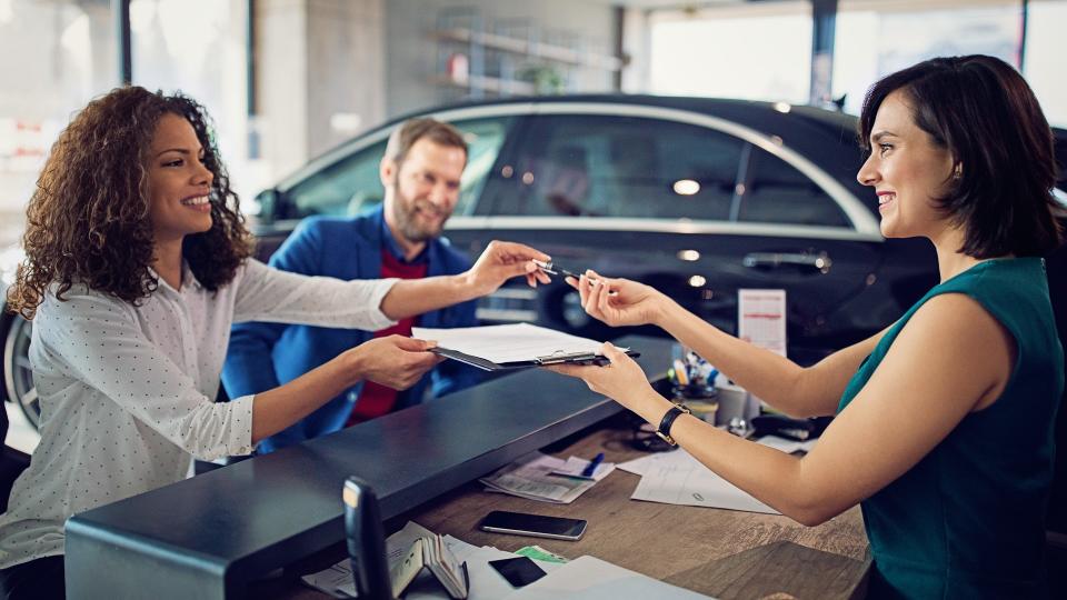 couple signing contract to lease new car