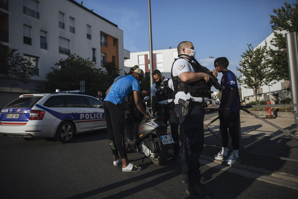 Police officers stop and search a motorbike rider and his passenger who did not wear any helmets, in the Paris suburb of Villiers-le-Bel, Tuesday, June, 15, 2021. In the run-up to France's presidential elections in 2022, crime and policing are again becoming hot-button issues. Some political opponents of President Emmanuel Macron argue that France is becoming an increasingly violent country. (AP Photo/Lewis Joly)