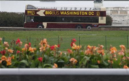 A tour bus with an empty top deck drives past the U.S. Capitol in Washington October 7, 2013. REUTERS/Jason Reed