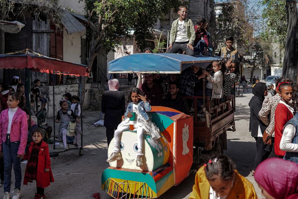 Children ride atop a motorcycle cart converted into a makeshift trackless train vehicle as they celebrate the Muslim holiday of Eid al-Fitr, after the end of the holy month of Ramadan, in Deir el-Balah in the central Gaza Strip on April 10, 2024.