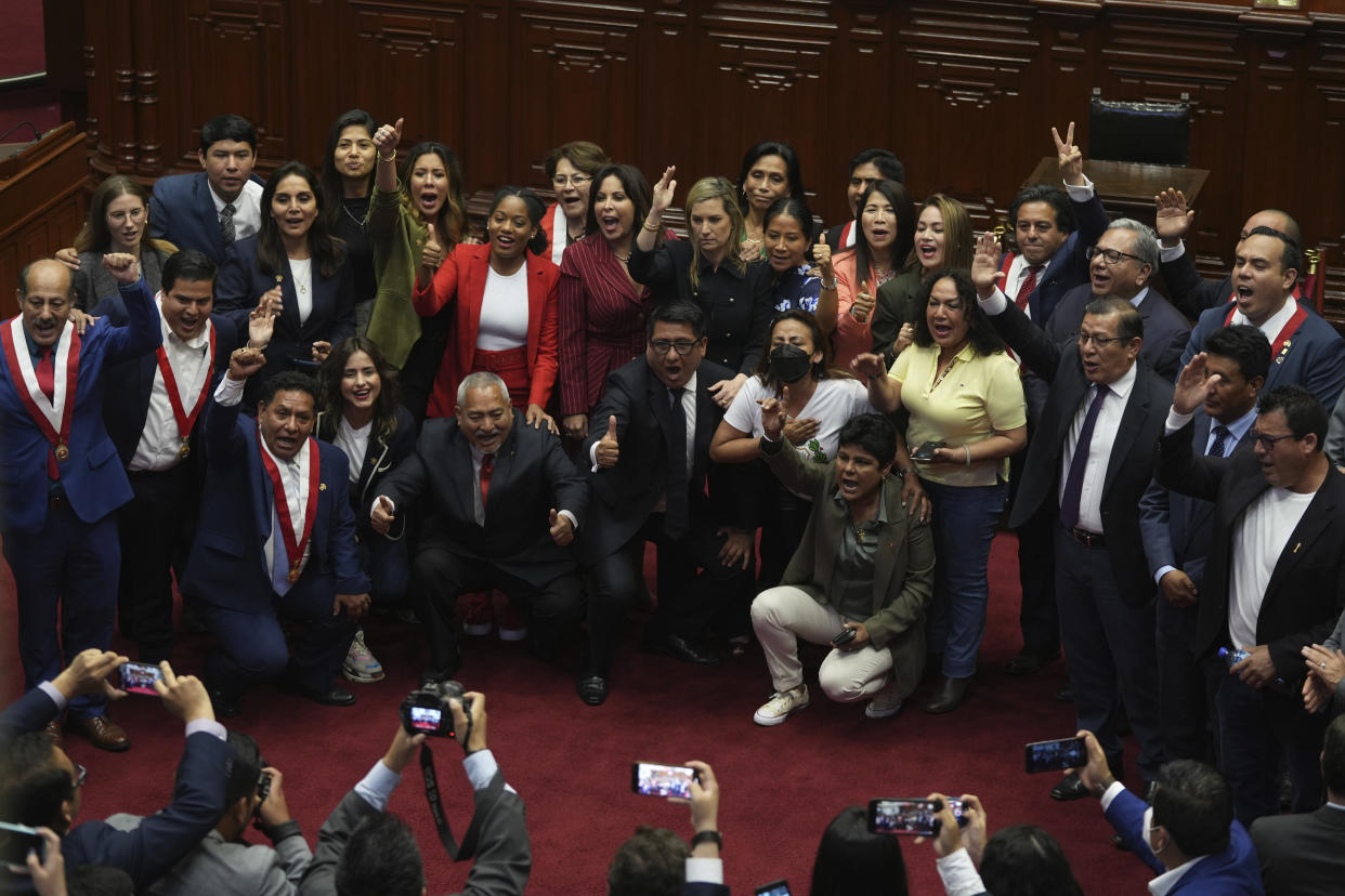 Lawmakers pose for photos as they celebrate after verbally voting to remove President Pedro Castillo from office in Lima, Peru, Wednesday, Dec. 7, 2022. Peru's Congress voted to remove Castillo from office Wednesday and replace him with the vice president, shortly after Castillo tried to dissolve the legislature ahead of a scheduled vote to remove him.(AP Photo/Guadalupe Pardo)