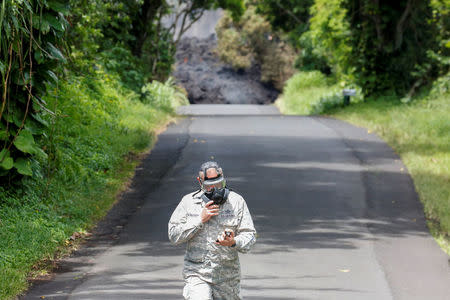 Lieutenant Colonel Charles Anthony, of the Hawaii National Guard, measures sulfur dioxide gas levels at a lava flow on Highway 137 southeast of Pahoa during ongoing eruptions of the Kilauea Volcano in Hawaii, U.S., May 20, 2018. REUTERS/Terray Sylvester