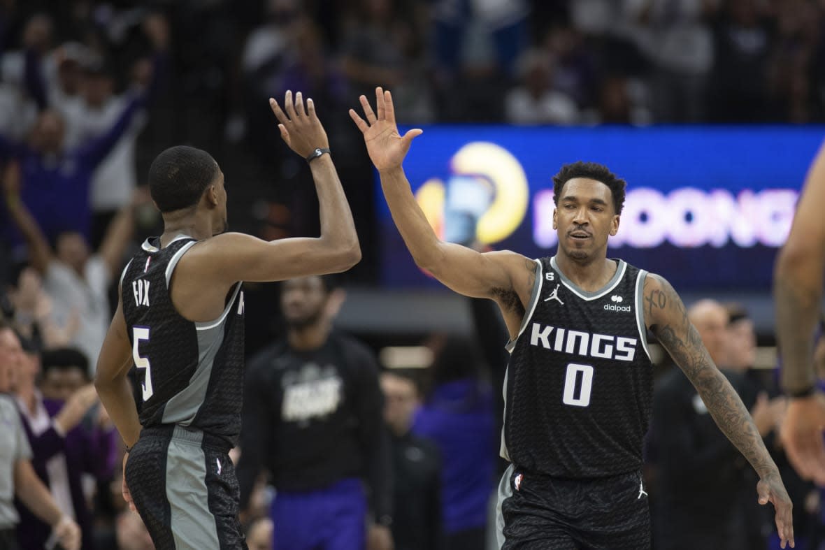 Sacramento Kings guards De’Aaron Fox (5) and Malik Monk (0) celebrate in the third quarter during Game 1 against the Golden Sate Warriors in the first round of the NBA basketball playoffs in Sacramento, Calif., Saturday, April 15, 2023. The Kings won 126 – 123. (AP Photo/José Luis Villegas)