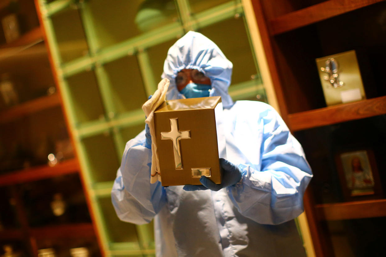 An employee wearing protective clothing disinfects a box for holding ashes at Funeral Gayosso, as the outbreak of the coronavirus disease (COVID-19) continues in Mexico City, Mexico May 11, 2020. Picture taken May 11, 2020. REUTERS/Edgard Garrido