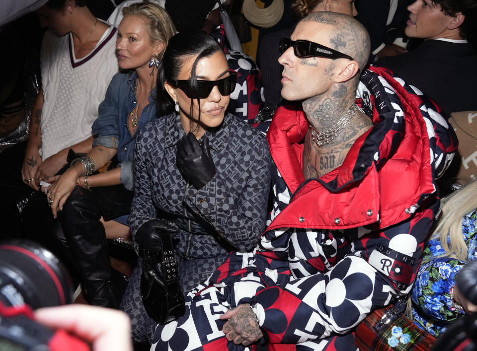 Kate Moss, from left, Kourtney Kardashian and Travis Barker attend the Tommy Hilfiger Fall 2022 fashion show at the Skyline Drive-In on Sunday, Sept. 11, 2022, in New York. (Photo by Charles Sykes/Invision/AP)