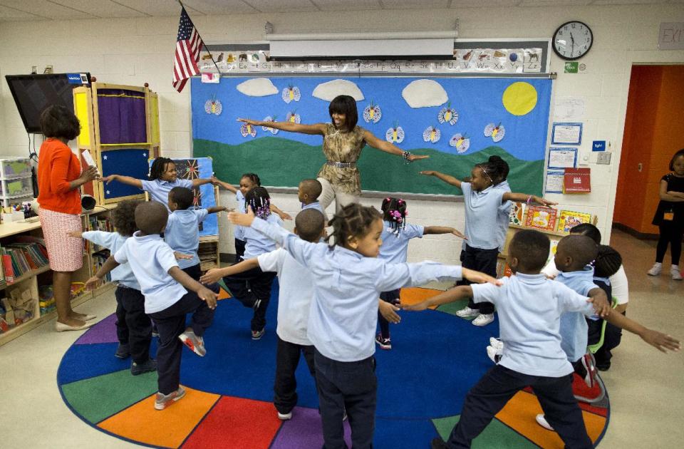 First lady Michelle Obama dances with a pre-K class at Savoy Elementary School in Washington, Friday, May 24, 2013. The Savoy School was one of eight schools selected last year for the Turnaround Arts Initiative at the President's Committee on the Arts and Humanities. Turnaround Arts Schools use the arts as a central part of their reform strategy to improve low performing schools (AP Photo/Evan Vucci)