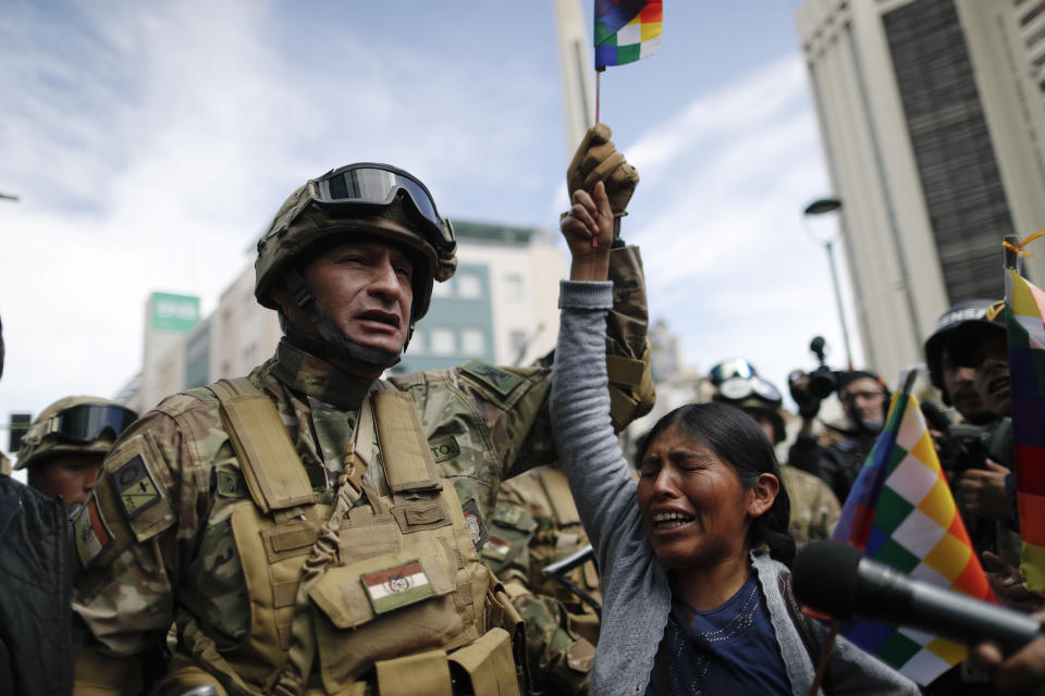 A woman cries in front of soldiers guarding a street during a march of supporters of former President Evo Morales in downtown La Paz, Bolivia, Nov. 15, 2019. Morales resigned on Nov. 10 at military prompting following massive nationwide protests over suspected vote-rigging in an election in which he claimed to have won a fourth term in office. (AP Photo/Natacha Pisarenko)