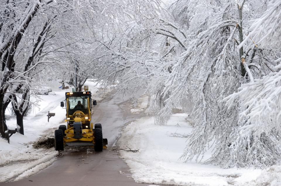 A grader clears snow after the Sioux Falls ice storm of 2013, which did heavy damage.