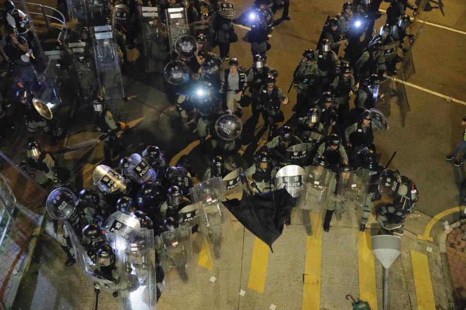 An umbrella is thrown at riot police during a confrontation in Wong Tai Sin district in Hong Kong on Saturday, Aug. 3, 2019. Protesters and authorities clashed in Hong Kong again on Saturday, as demonstrators removed a Chinese national flag from its pole and flung it into the city's iconic Victoria Harbour and police fired tear gas after some protesters vandalized a police station. (AP Photo/Kin Cheung)