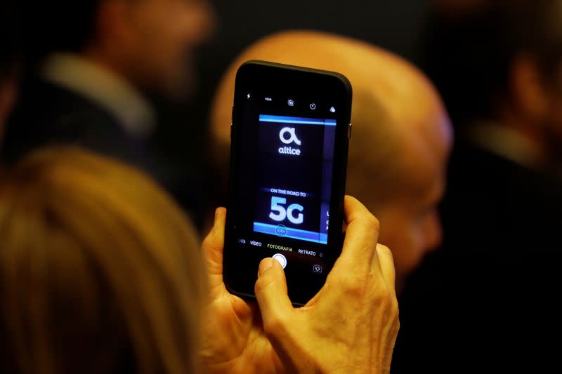 FILE PHOTO: A woman takes pictures during the first demonstration of the technology 5G in Lisbon