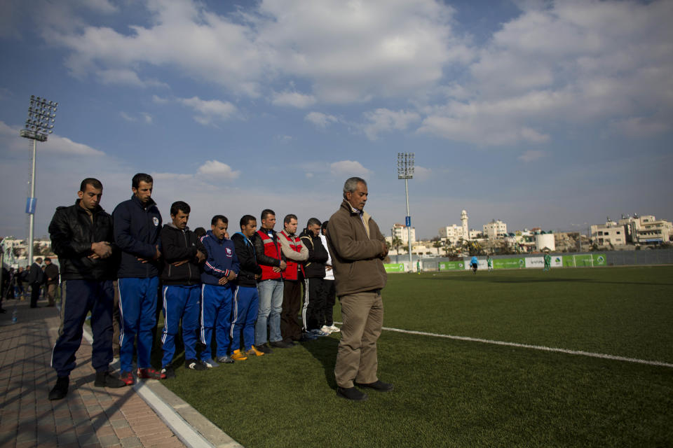 In this Friday Feb. 7, 2014, 2014 photo, Wadi al-Nees reserve players and team leaders pray before a league game at a stadium in Hebron, West Bank. Palestinian farmer Yousef Abu Hammad sired enough boys for a soccer team and the current roster of the Wadi al-Nees team includes six of Abu Hammad's sons, three grandsons and five other close relatives. Wadi al-Nees heads the West Bank's 12-team “premier league,'' consistently defeating richer clubs and believe their strong family bonds are a secret to their success. (AP Photo/Dusan Vranic)