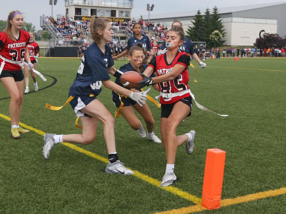 Penfield's Mallory Pietrzak reaches over the goal line ahead of Webster Thomas's Madalyn Kelly and Alexis Eskander to score late in the second half during their flag football Class A sectional Championship game.