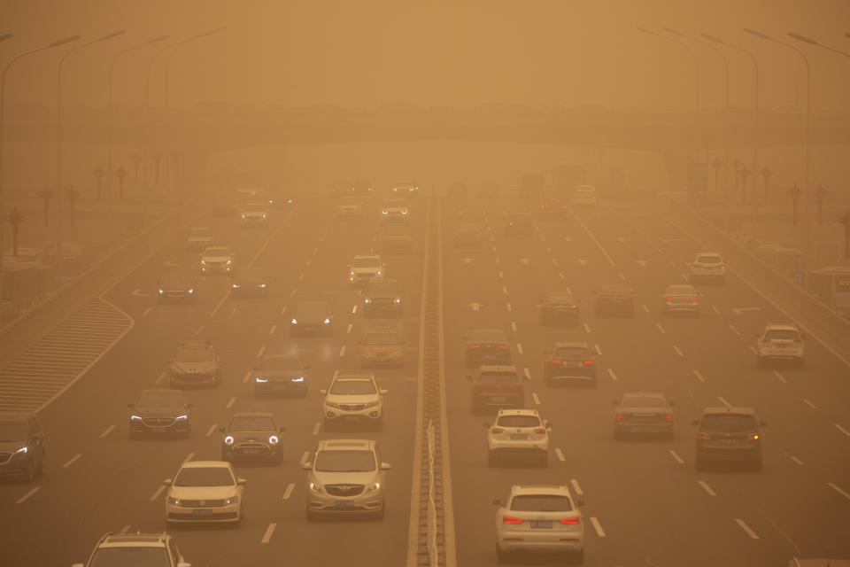Cars are driven along an expressway amid a sandstorm during the morning rush hour in Beijing. (AP Photo/Mark Schiefelbein)