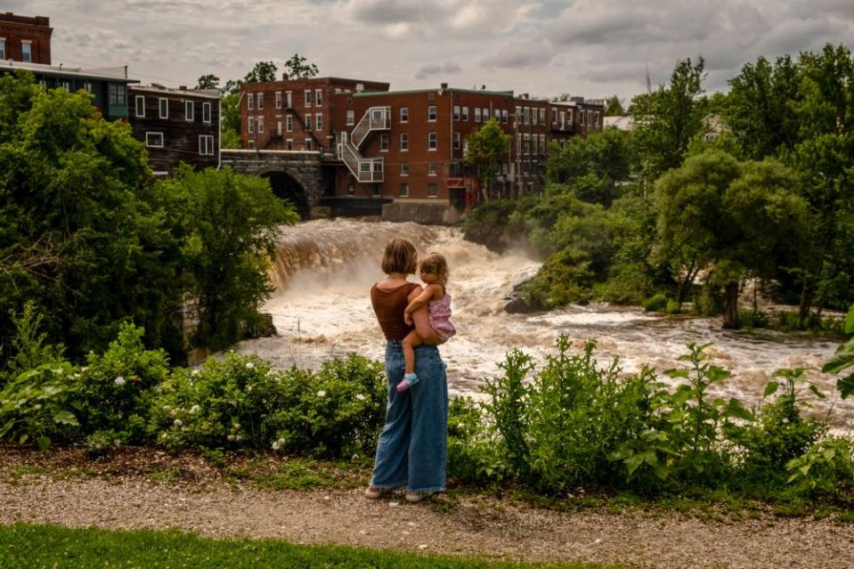 Lauren Rowley and her daughter Ursula, 2, look at the surging Otter Creek River in downtown Middlebury, Vt., on July 14. Vermont began new flood protection efforts after being battered by Tropical Storm Irene in 2011. <span class="copyright">Hilary Swift—The New York Times/Redux</span>