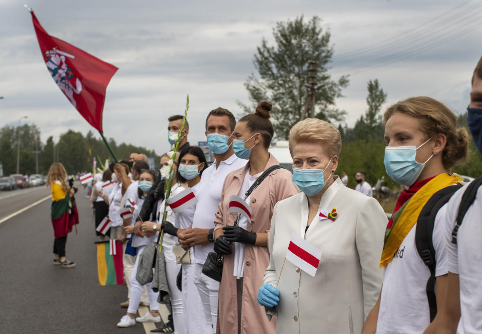 Former Lithuanian President Dalia Grybauskaite, second from right, and other supporters of Belarus opposition participate in a "Freedom Way", a human chain of about 50,000 strong from Vilnius to the Belarusian border, during a protest near Medininkai, Lithuanian-Belarusian border crossing east of Vilnius, Lithuania, Sunday, Aug. 23, 2020. In Aug. 23, 1989, around 2 million Lithuanians, Latvians, and Estonians joined forces in a living 600 km (375 mile) long human chain Baltic Way, thus demonstrating their desire to be free. Now, Lithuania is expressing solidarity with the people of Belarus, who are fighting for freedom today. (AP Photo/Mindaugas Kulbis)